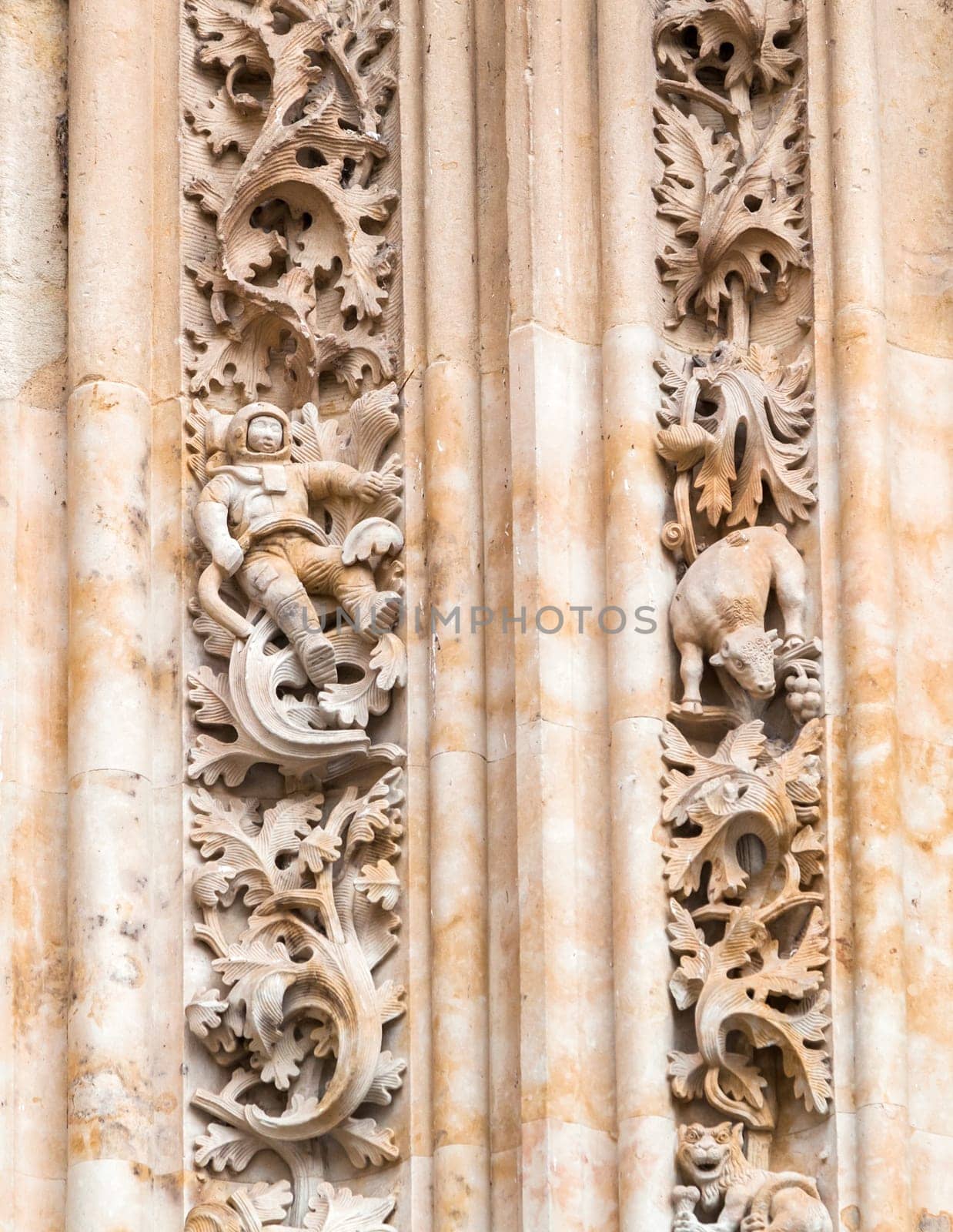 A detailed view of stone sculptures at the Salamanca Cathedral showcases an astronaut among intricate foliage.