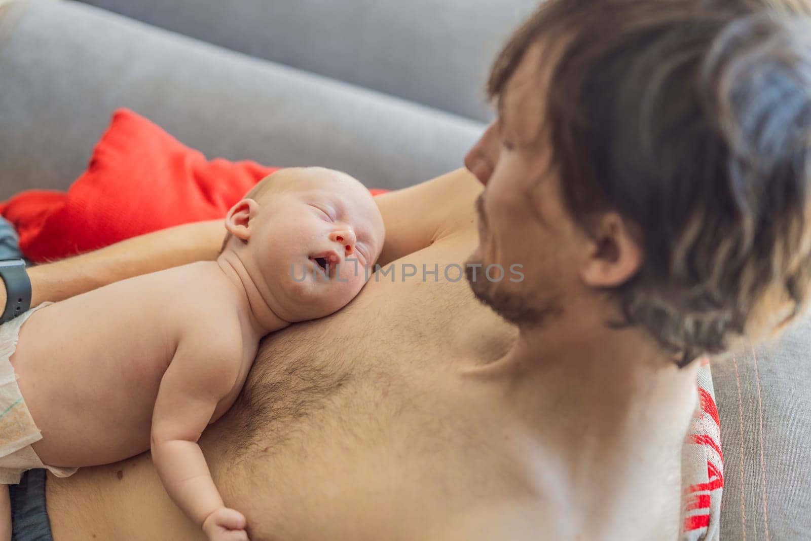 A newborn baby rests peacefully on the father's chest, feeling the warmth and heartbeat of his parent. A tender moment of bonding, love, and security, symbolizing the deep connection between father and child.