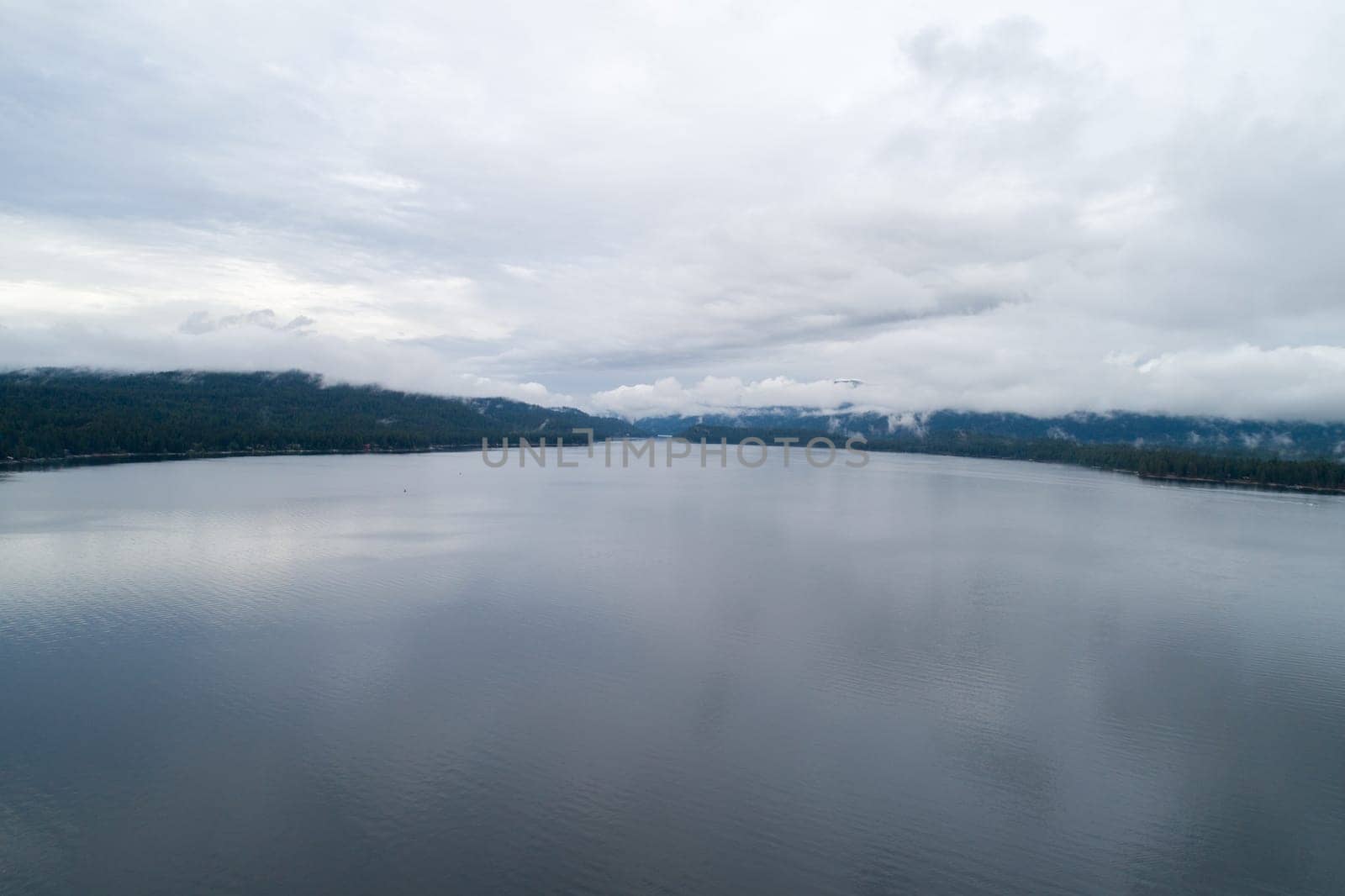 The sky is cloudy and the water is calm. The reflection of the clouds can be seen on the water