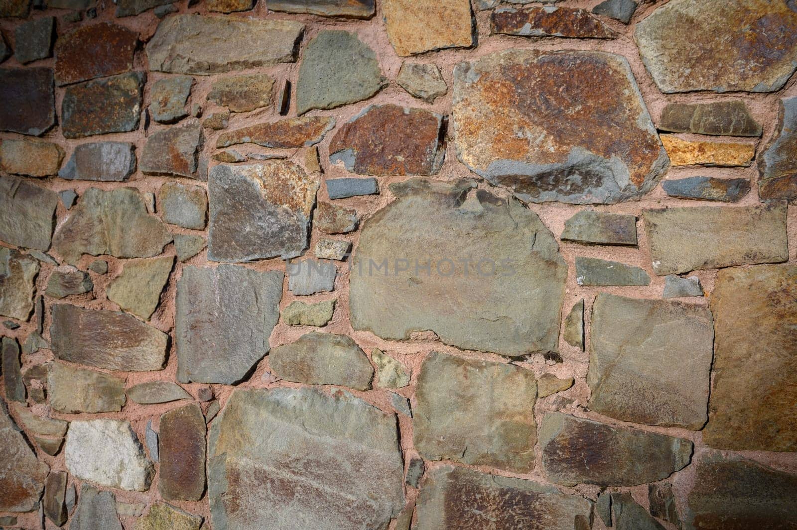 Weathered stones in various shades create a textured, rustic wall that speaks of history and craftsmanship.