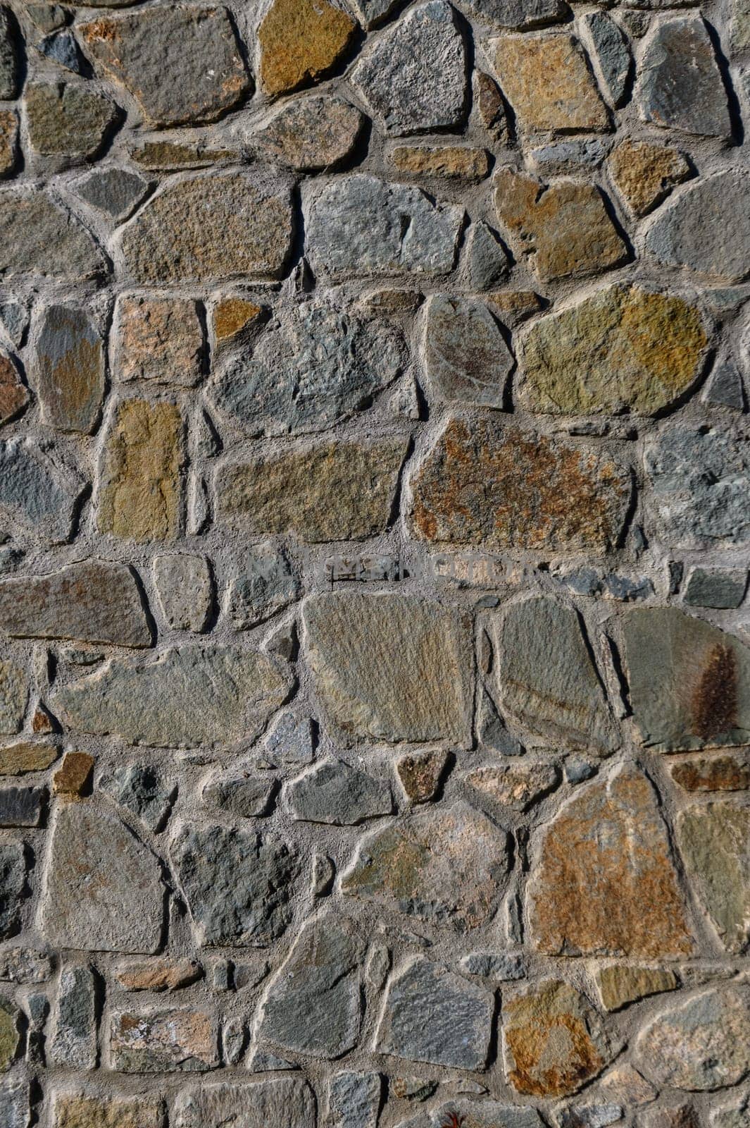 Roughly arranged stones showcase earthy colors and varying shapes, highlighting craftsmanship in a historical setting.
