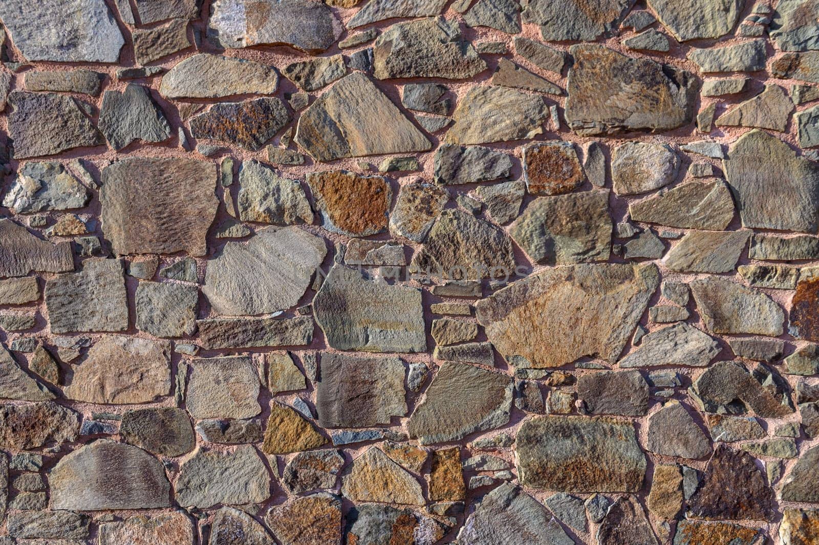 A stunning display of various stones creates a unique texture on a wall, reflecting the beauty of natural materials.