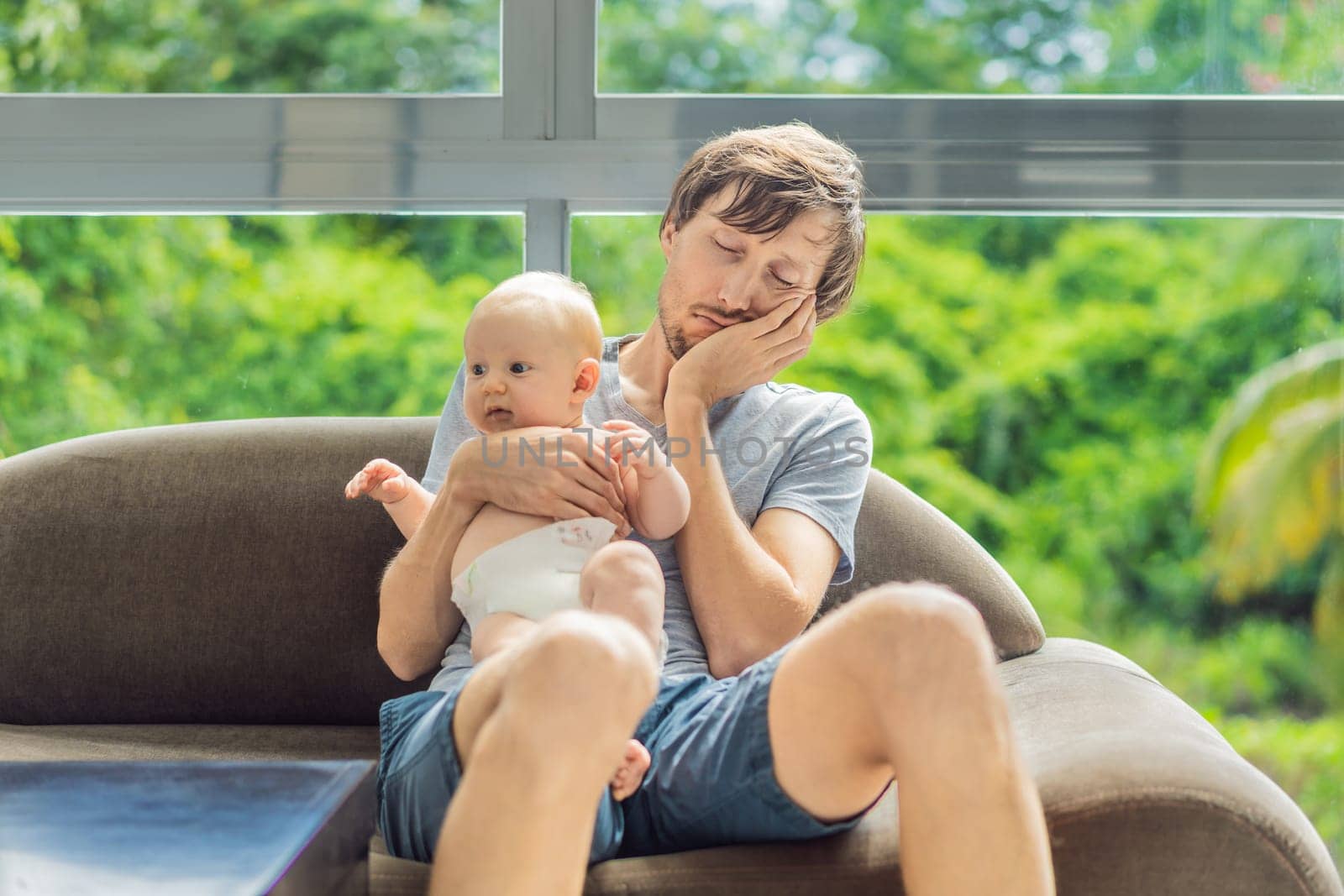 An exhausted father falls asleep on the couch while holding his 3-month-old baby in his arms. A tender and heartwarming moment showcasing love, caregiving, and the challenges of parenthood. Family and bonding concept.