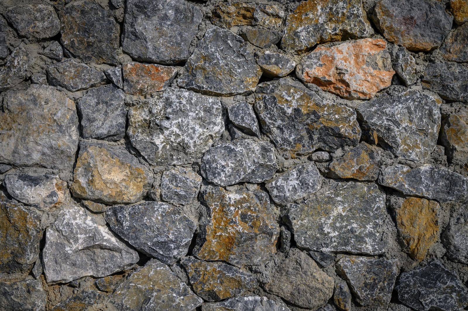 Rugged stones in various shades create a timeless wall, showcasing nature's artistry and the passage of time.