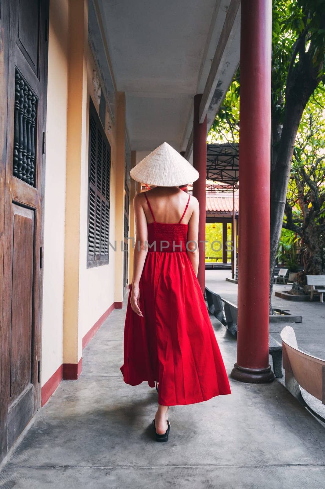 back of a Vietnamese tourist woman in Non La hat at a pagoda temple in Vietnam on a trip to Asia