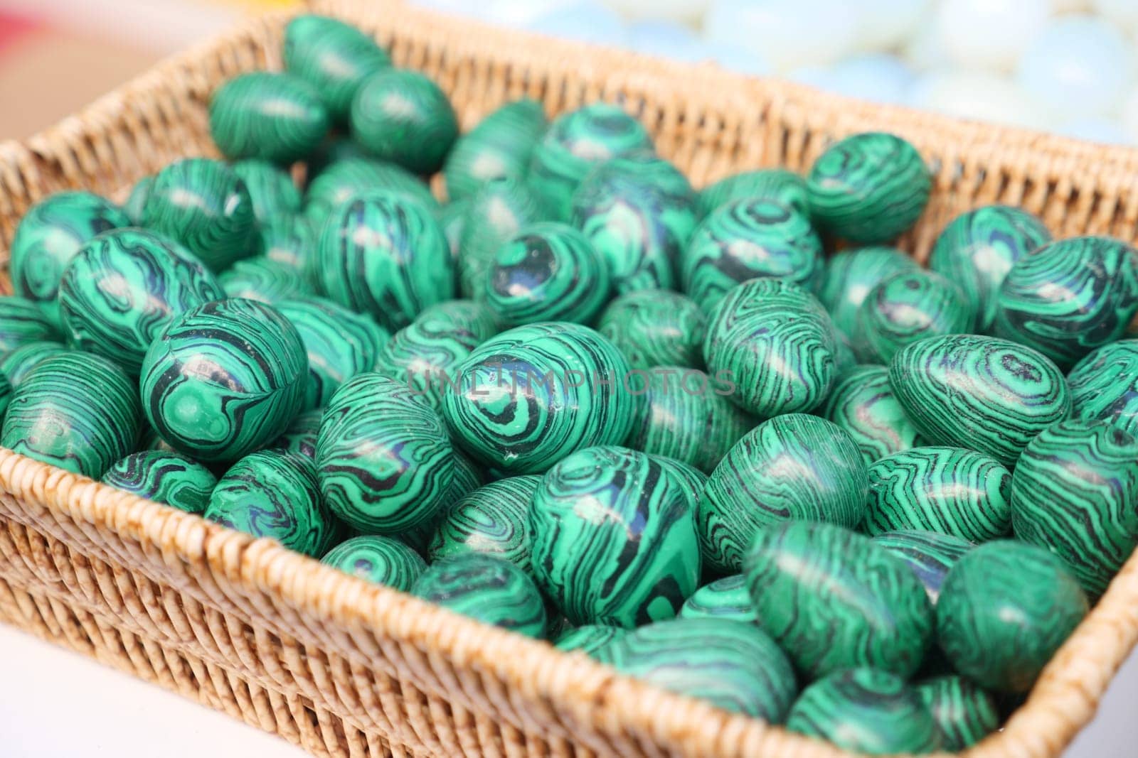 A basket filled with vibrant green decorative stones displaying unique patterns.