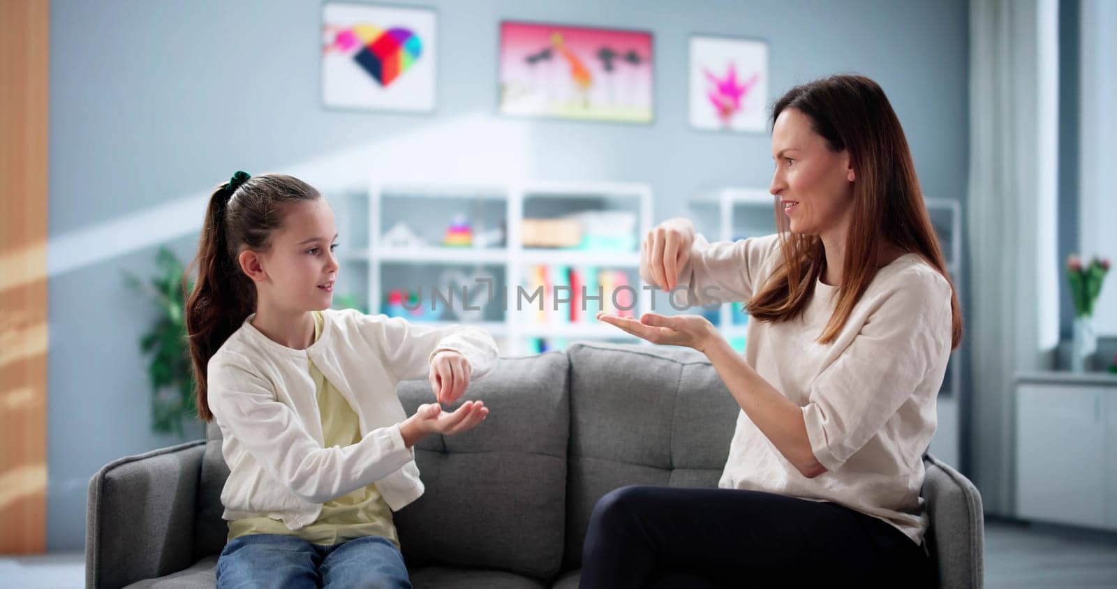 Young girl learns sign language from teacher to overcome hearing disability.
