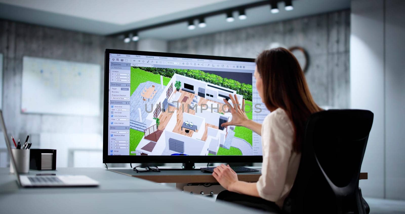 Female architect using 3D software to remodel real estate.