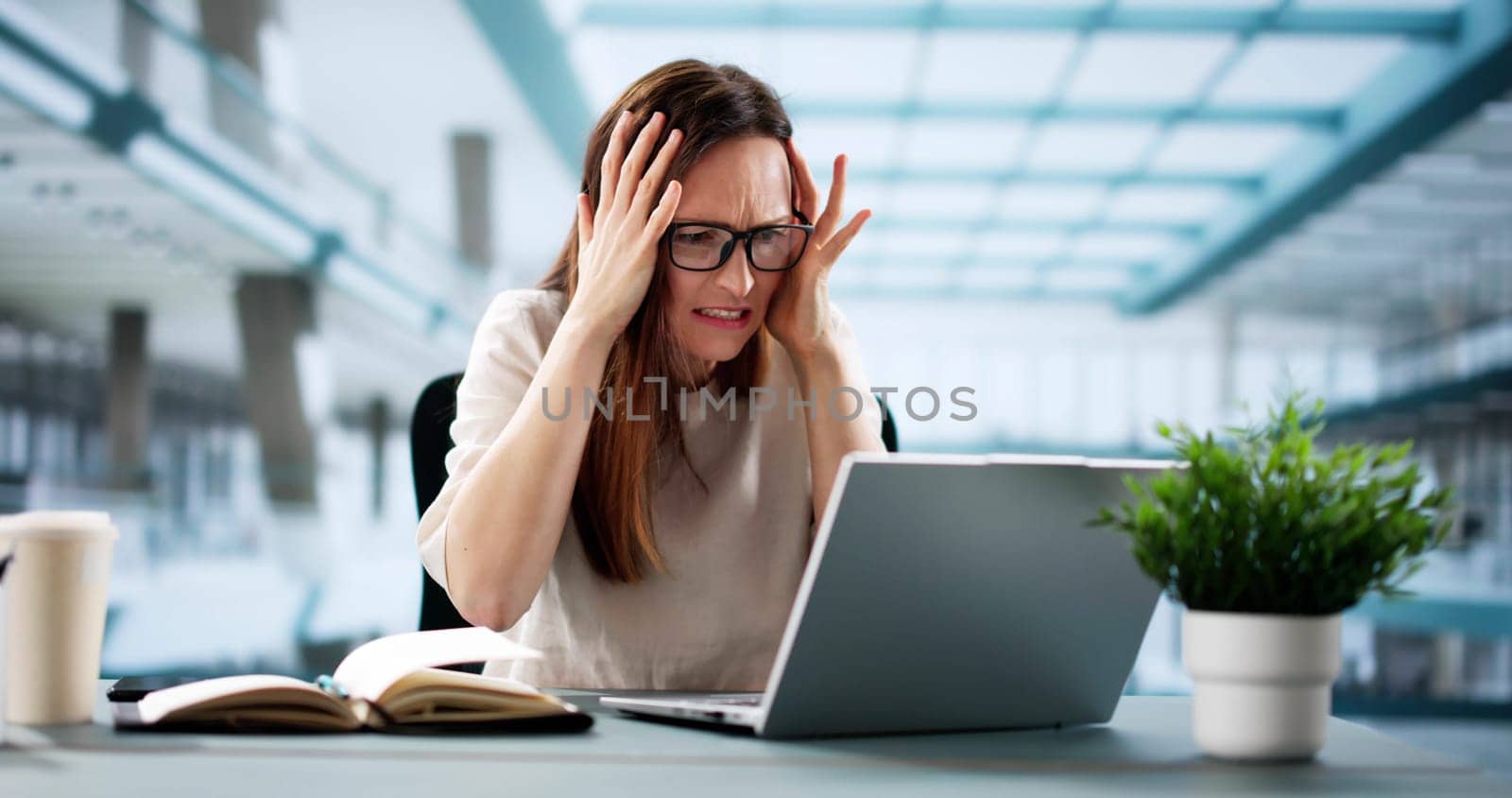 Businesswoman shocked by ransomware attack on office computer privacy breach.