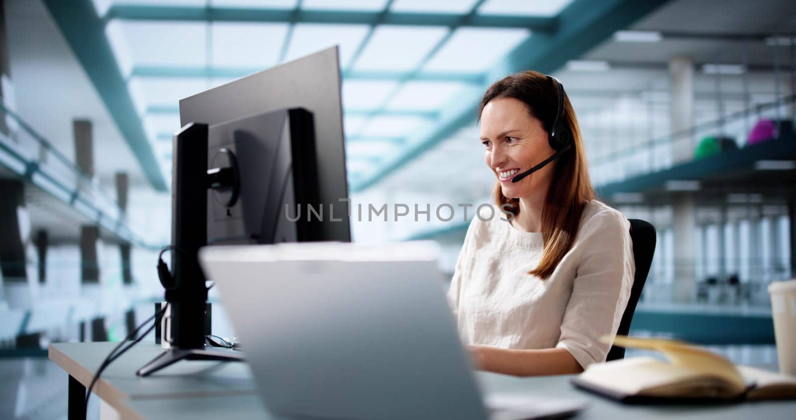 Efficient female customer service agent speaking with happy remote client.