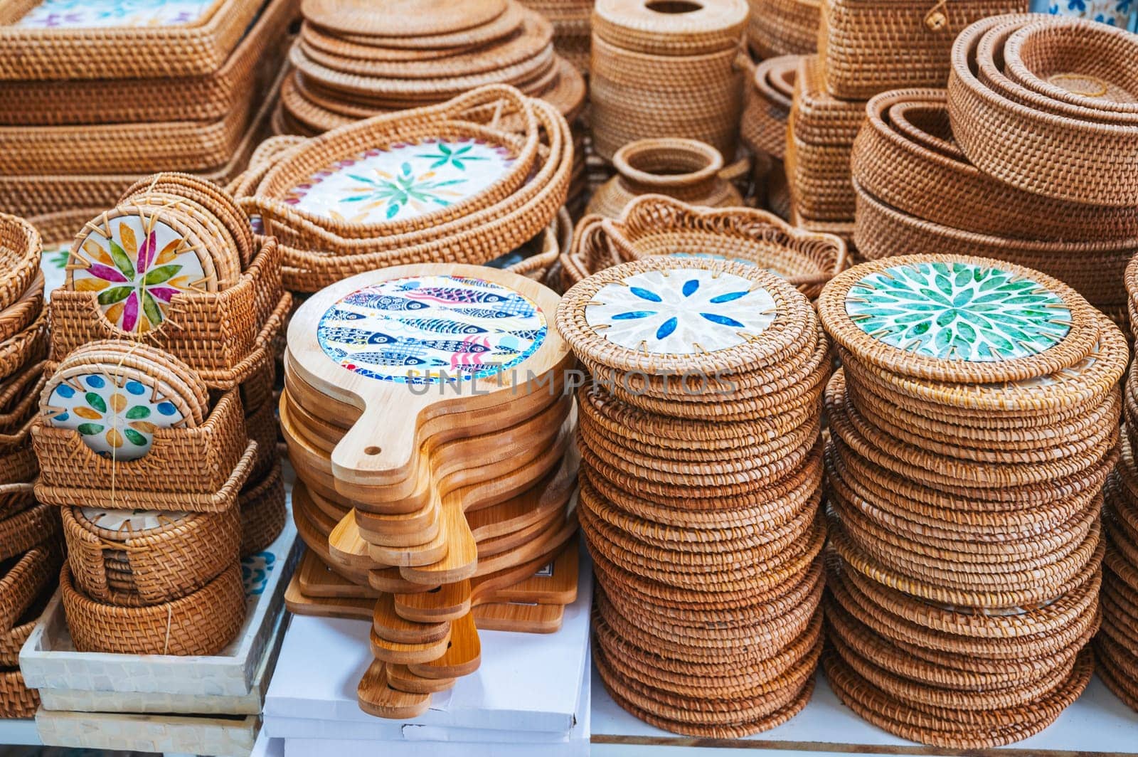 wicker baskets and containers and handmade wooden tableware on the counter at Asian market in Vietnam