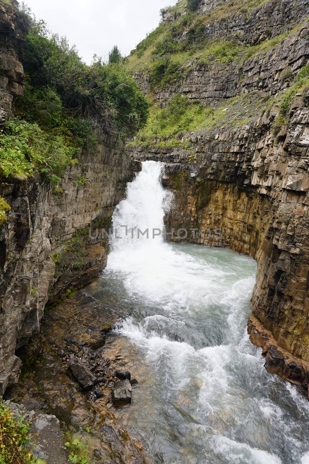 White water cascading down natural rock formations in glacier national park, montana, showcases the stunning beauty and raw power of nature in a serene wilderness landscape