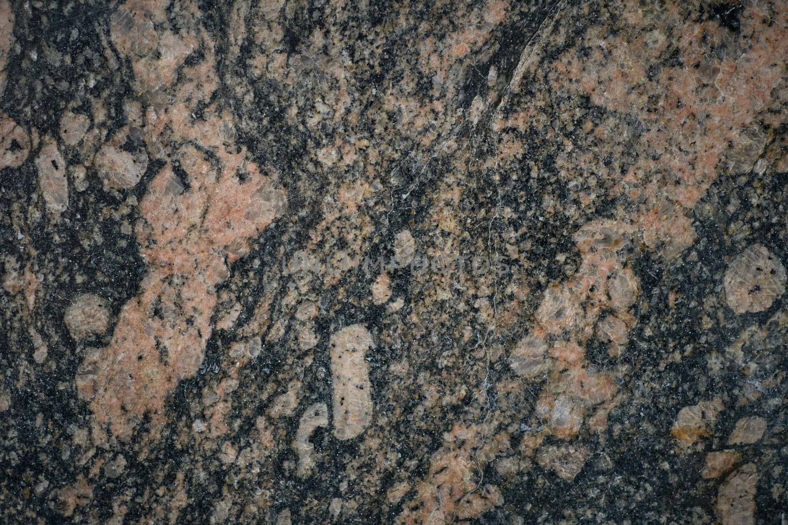 Close-up view of granite rock face, highlighting natural texture and mineral composition.
