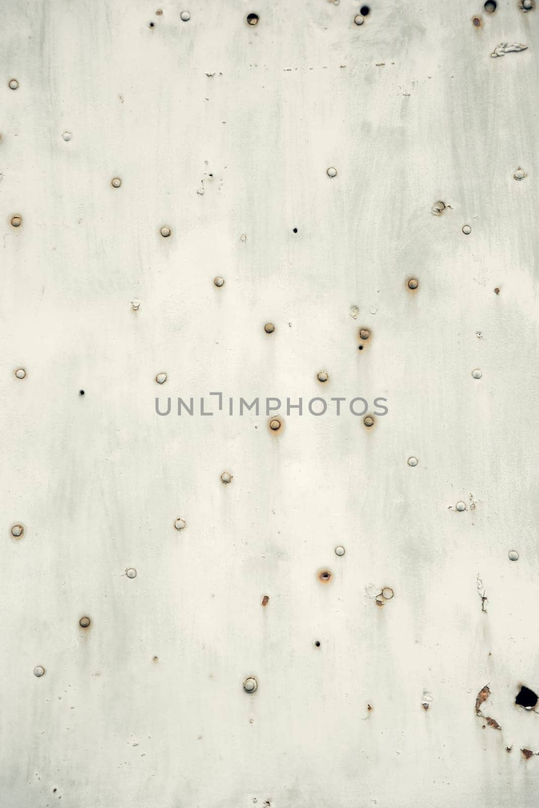 A textured close-up of a weathered metal surface with rusted rivets and signs of aging. Ideal for industrial, grunge, and vintage design backgrounds