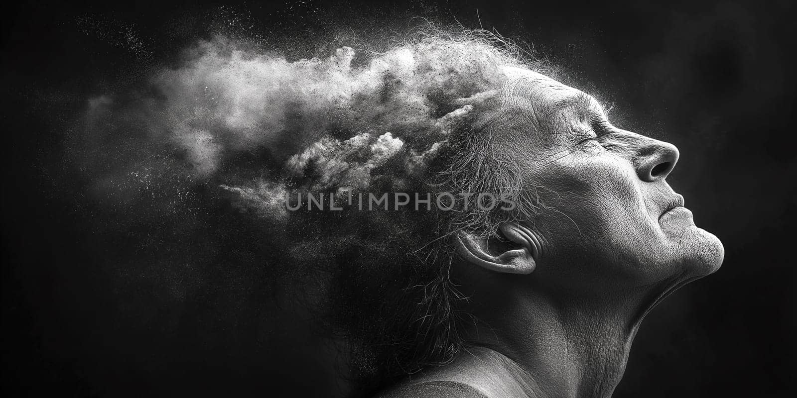 A grayscale image shows an elderly person, possibly a woman, with dust or powder swirling around their head. The image evokes a sense of release or letting go.