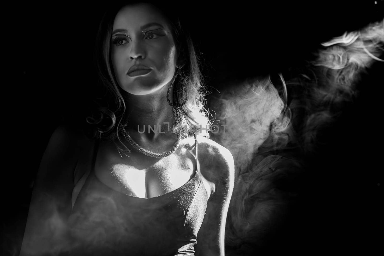 A striking black and white portrait beautifully capturing a contemplative model surrounded by swirling smoke