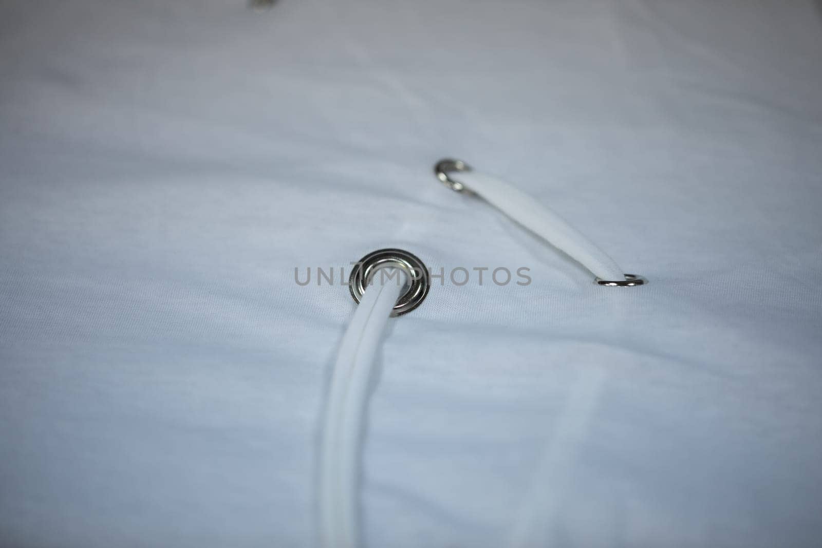 This is a detailed view of a grommet that features a white lace intricately threaded through it and around