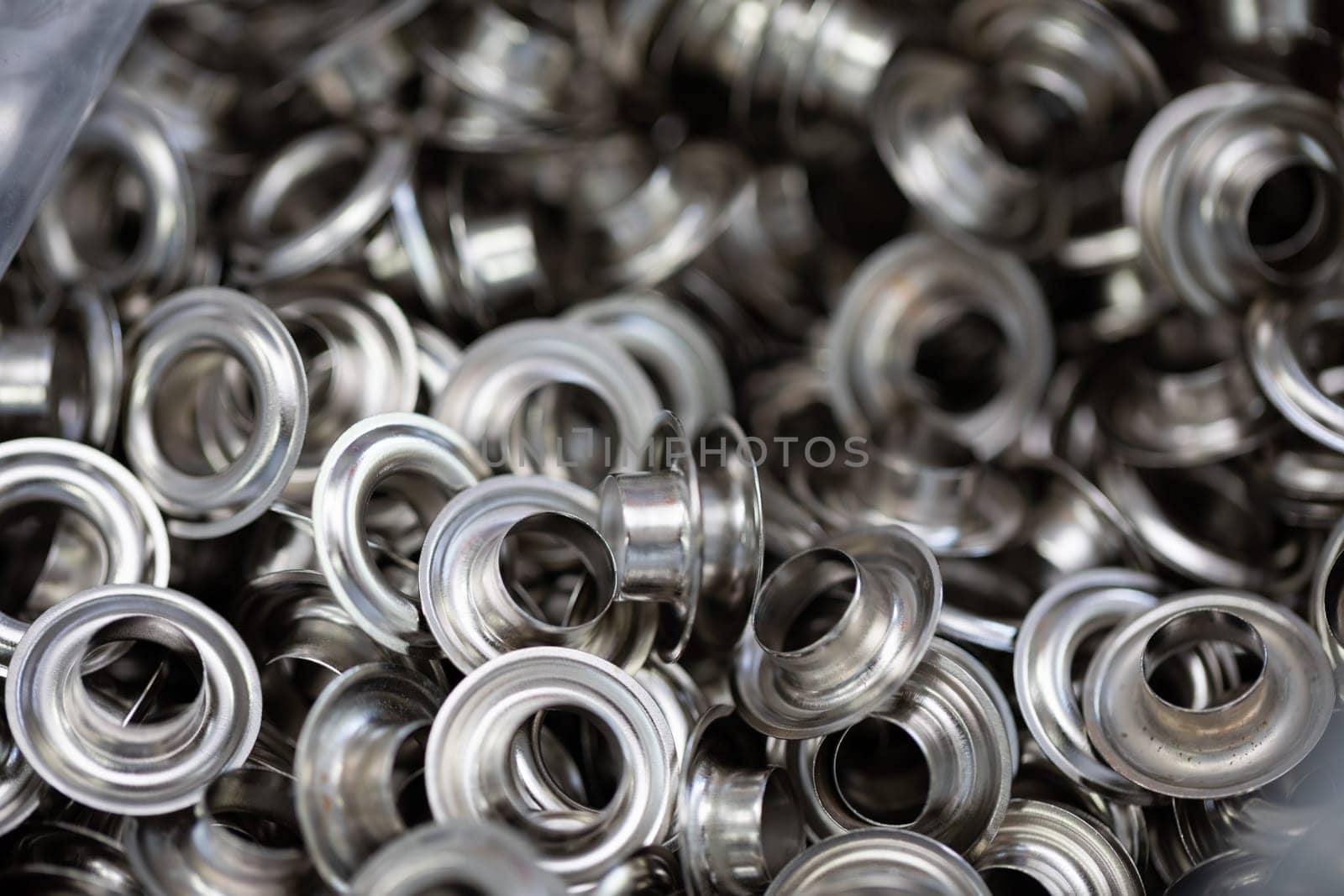 Detailed view of metallic grommets and eyelets, perfect for various crafting and sewing applications.