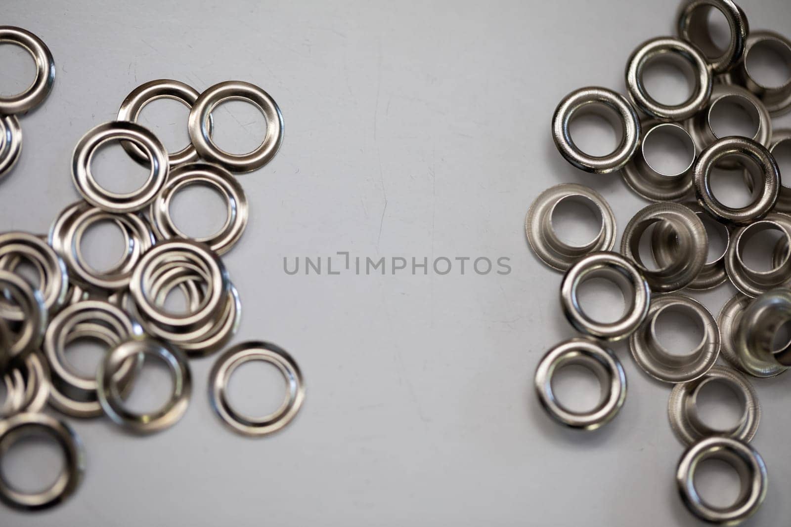 A stunning collection of shiny silver metal rings beautifully arranged on a neutral gray background surface