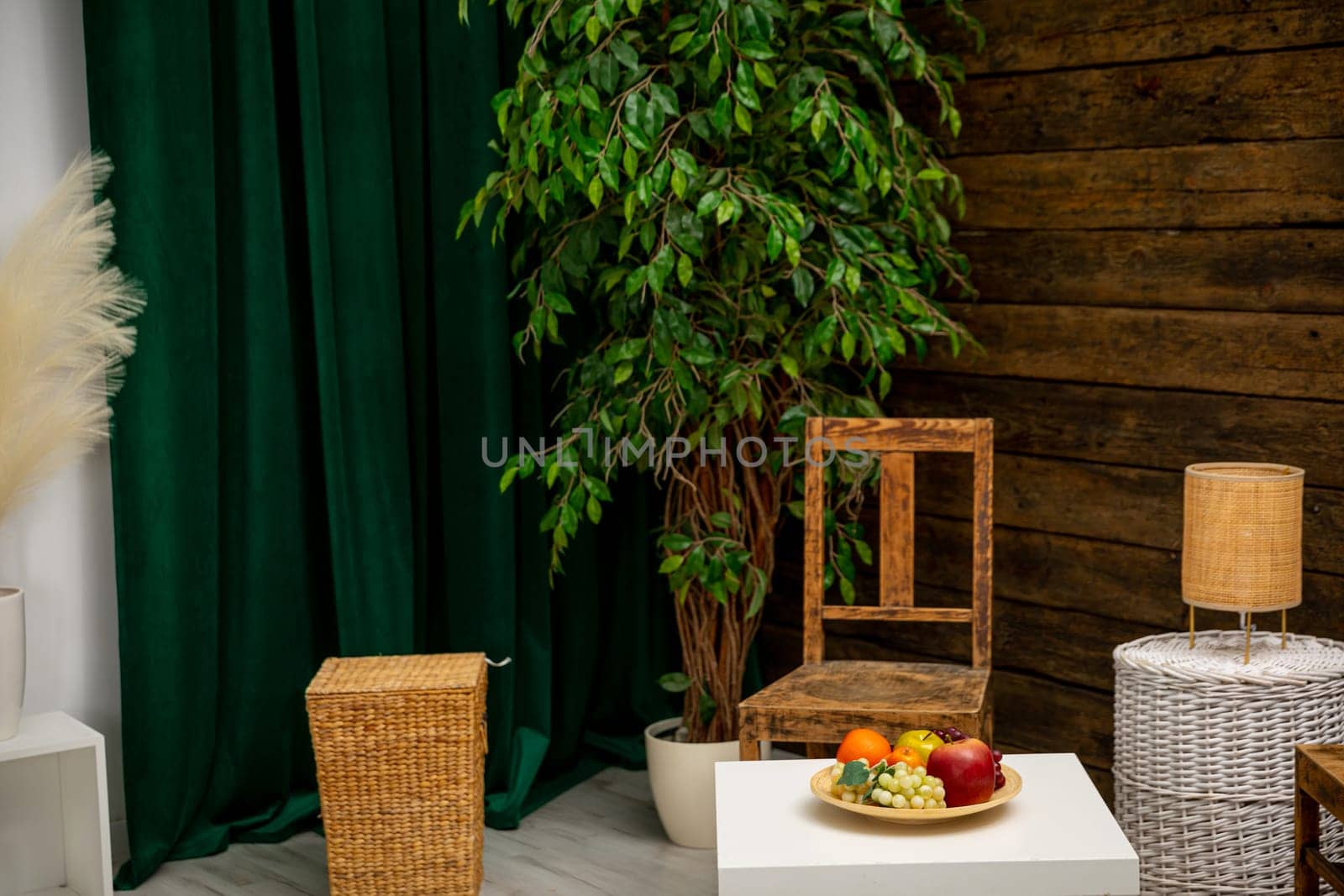A serene setup with a green backdrop, stylish wooden furniture, and a colorful array of fresh fruits