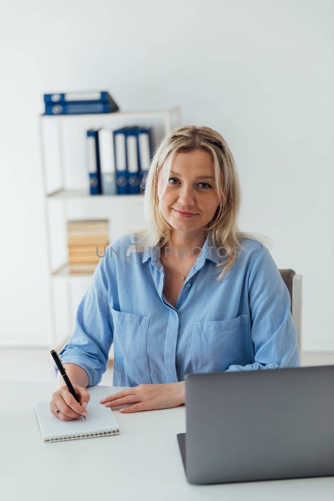 woman blonde working with laptop online in office