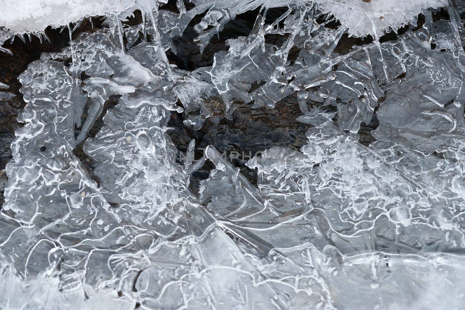 Frozen stream and ice closeup photo. Beautiful winter abstract background in nature. Concept for water and winter time
