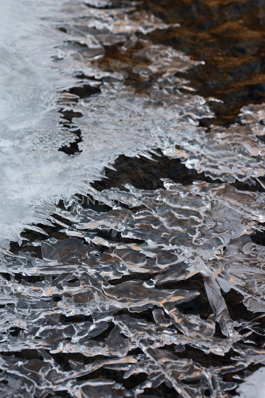 Frozen stream and ice closeup photo. Beautiful winter abstract background in nature. Concept for water and winter time