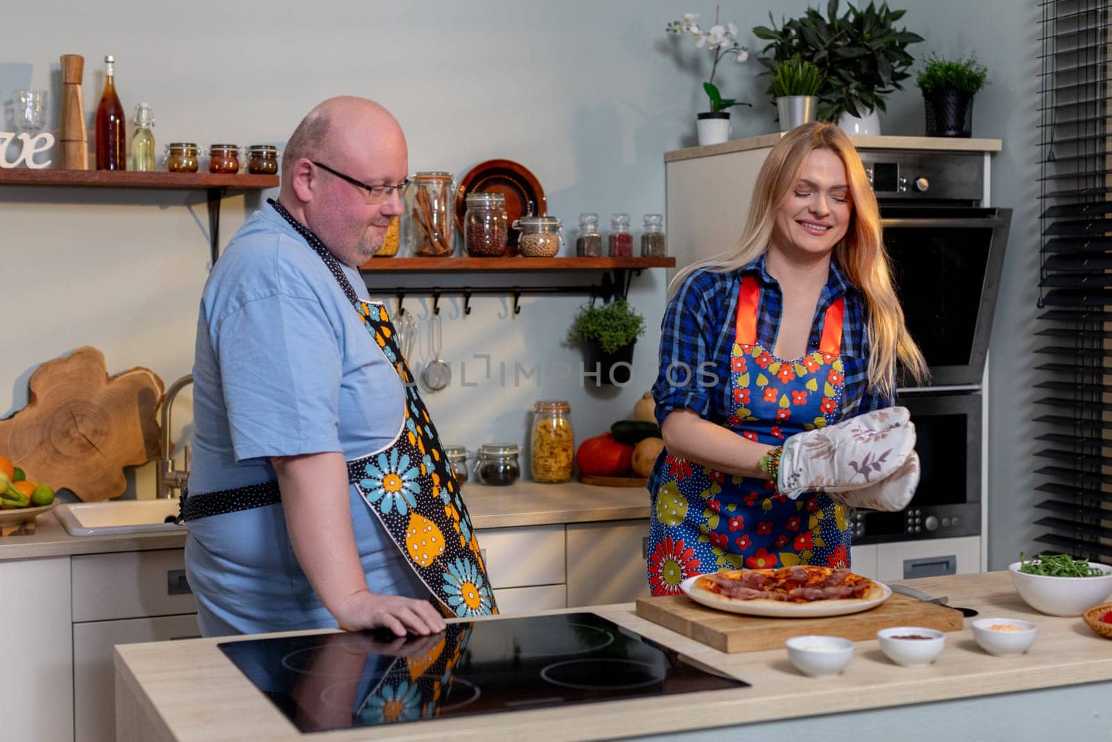 A delightful and joyful cooking scene with two cheerful chefs wearing vibrant aprons preparing a delicious dish