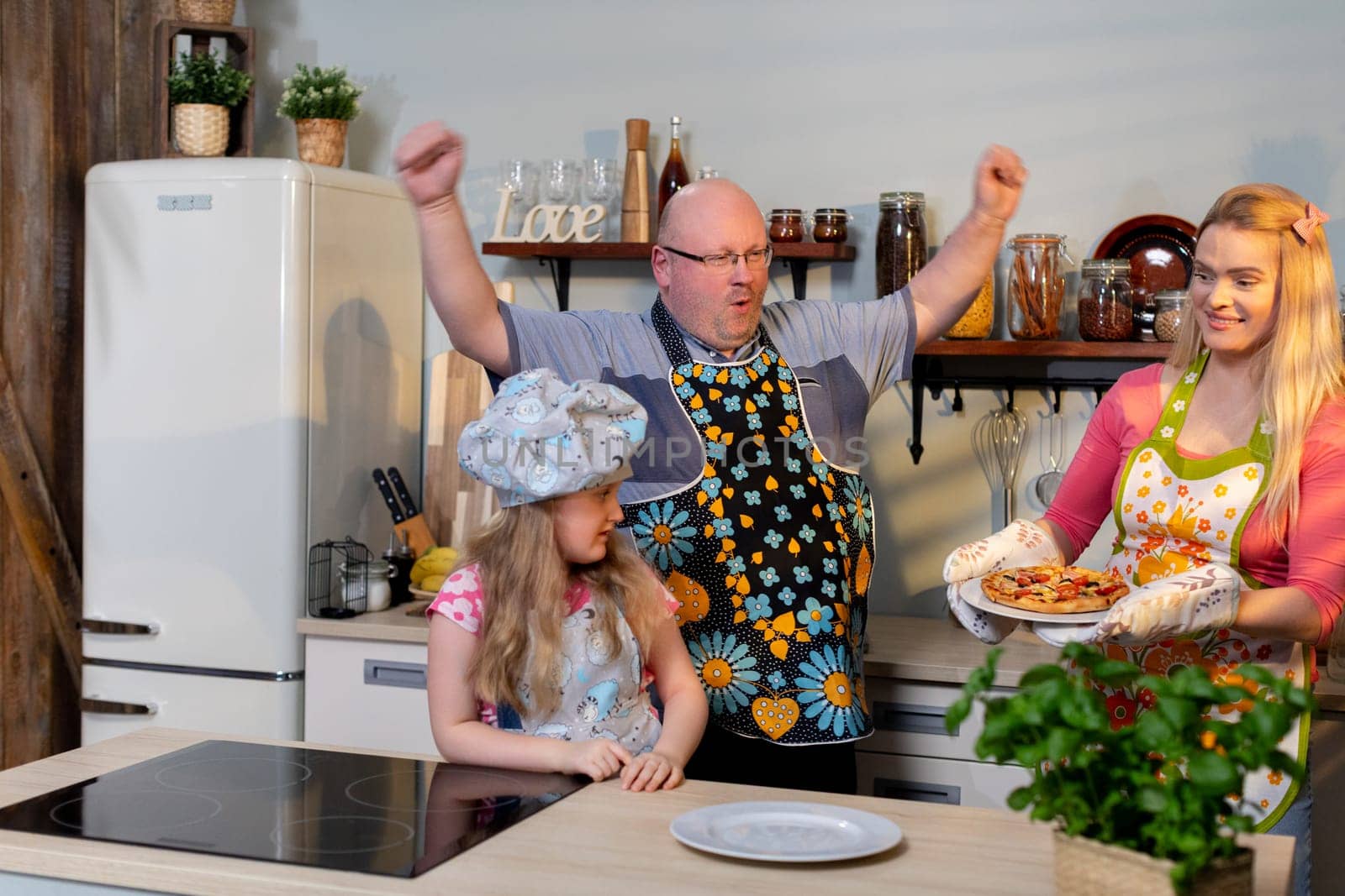 A joyful and cheerful family happily engages in cooking together, showcasing their creativity and unity in the kitchen