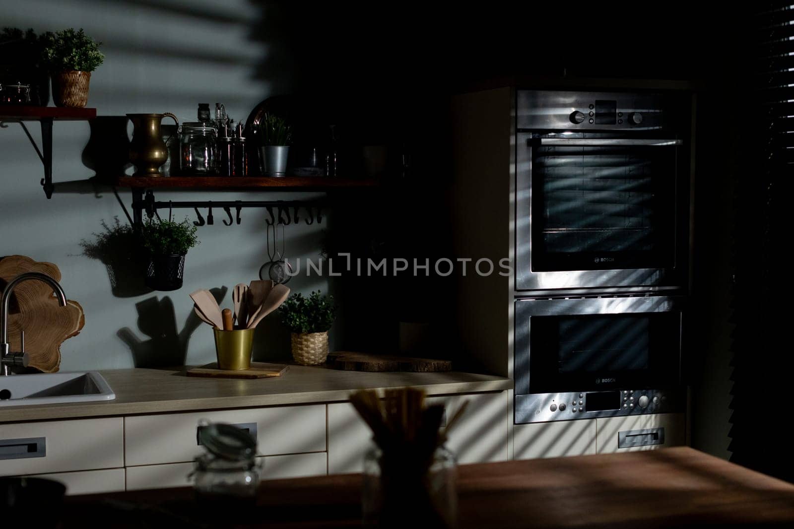 A beautifully designed modern kitchen that showcases elegant decor, ambient lighting, and stunning shadow effects