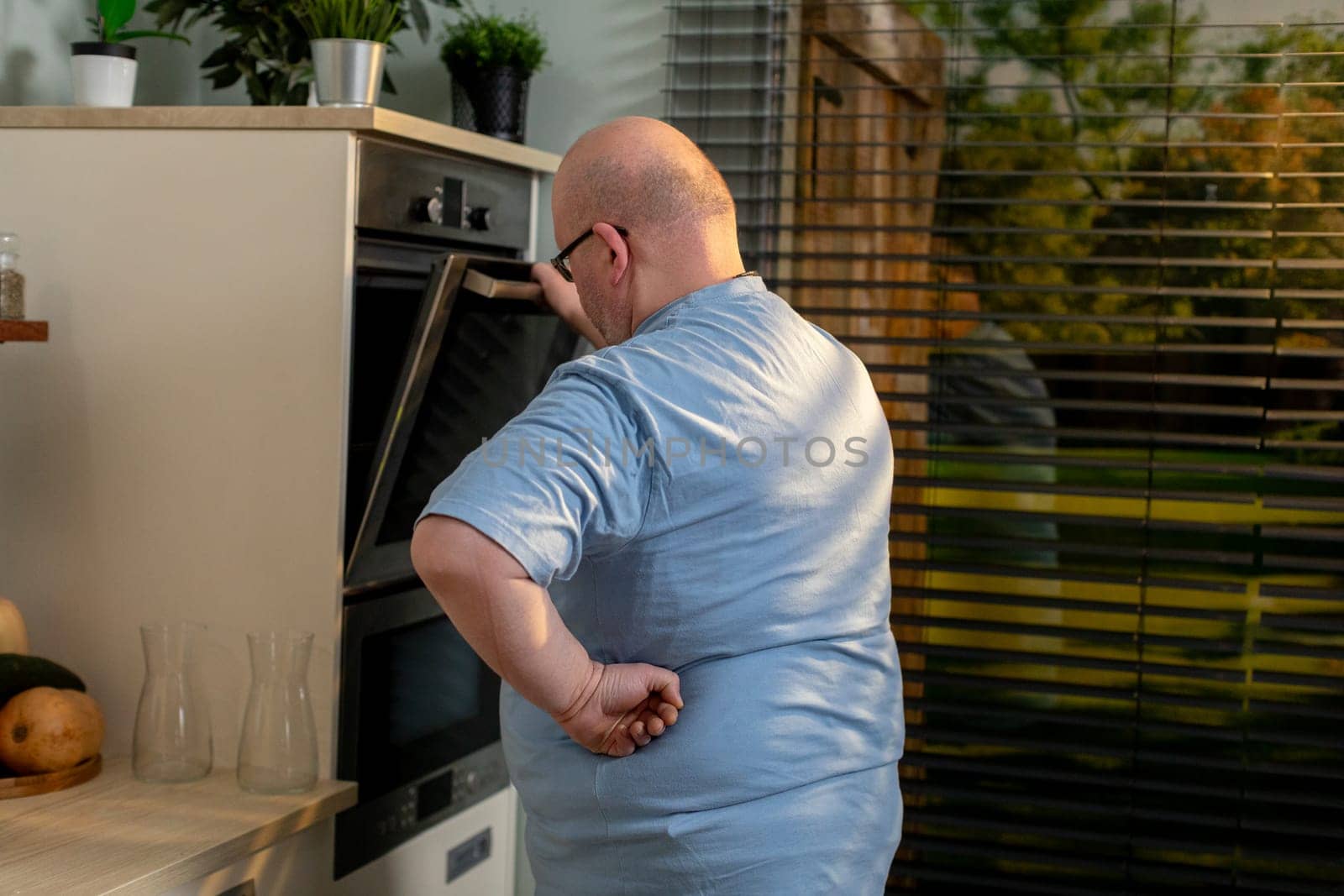 A man is attentively monitoring and checking his dish in a modern kitchen, showcasing the pure joy of home cooking