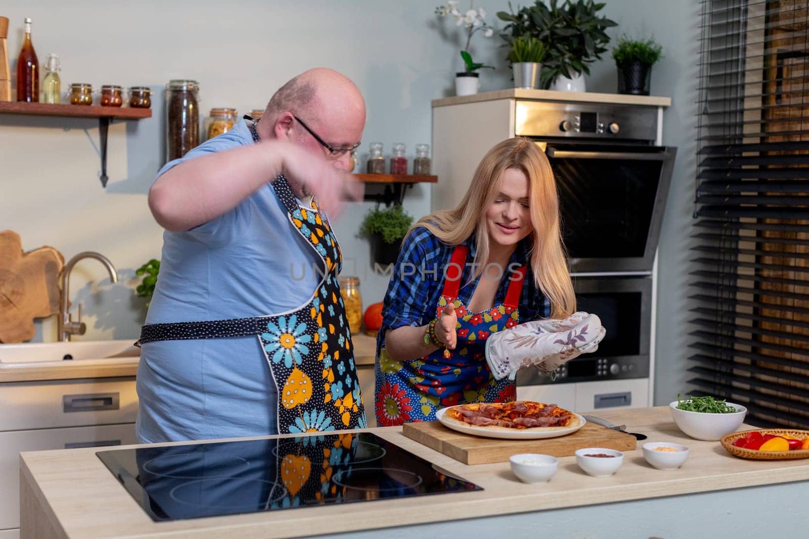 A joyful cooking scene with two individuals creating a delicious meal together with enthusiasm and happiness