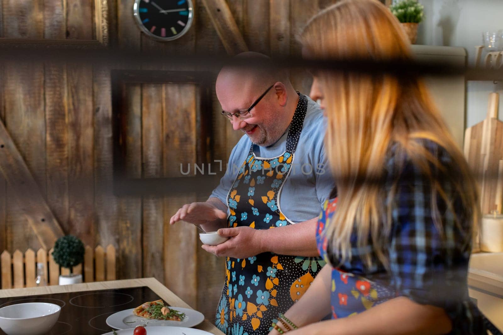 In a rustic kitchen, two cheerful chefs prepare a delicious meal, creating a warm and inviting atmosphere