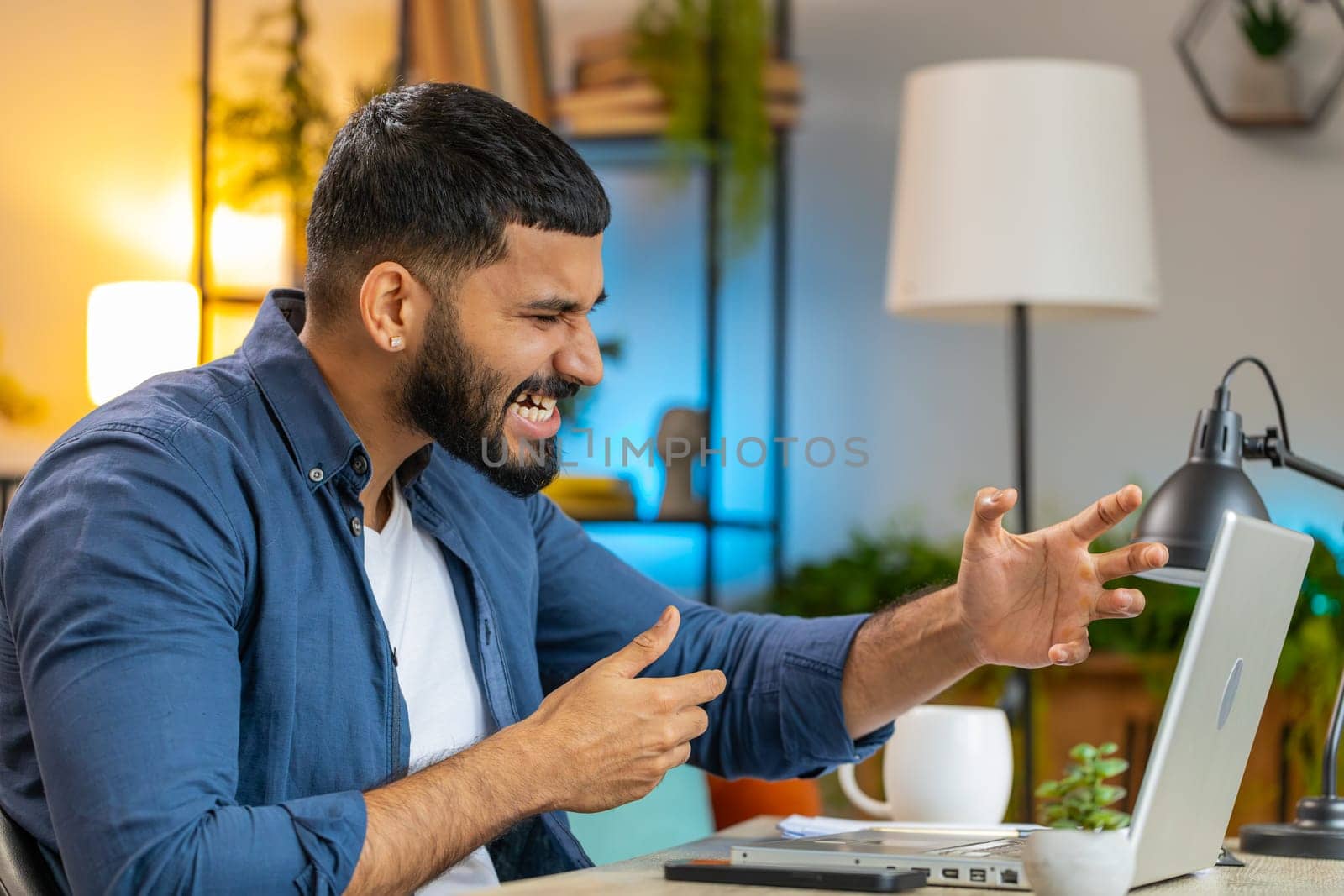 Conflict quarrel negotiation. Angry Hispanic freelancer man making webcam laptop online video call at home office. Upset mad manager talking conversation analyzing financial report mistake problem.