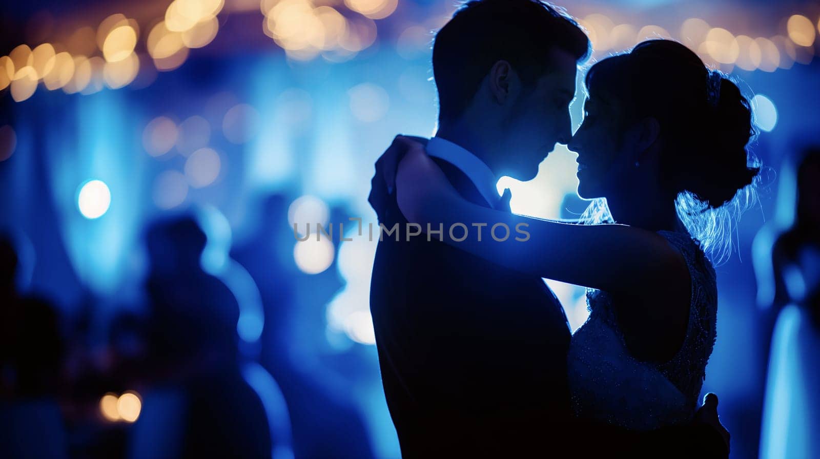 A couple shares an intimate moment while dancing at a wedding reception, surrounded by softly glowing blue lights and other guests enjoying the celebration - Generative AI