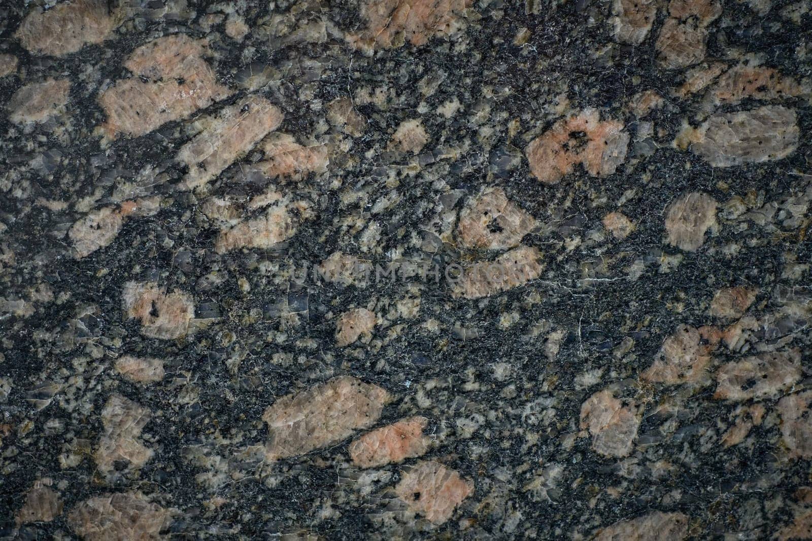 Granite stone showing pink feldspar crystals embedded in dark matrix