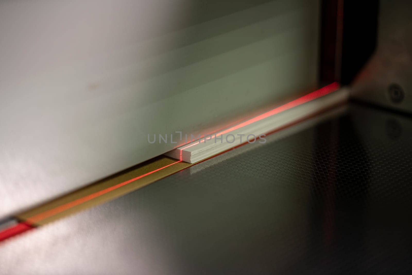 Crop of laser line on paper of modern digital cutting machine in workshop