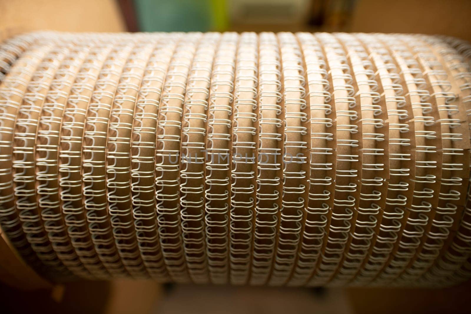 Rounded detail for professional machine tool with identical spirals for paper notebooks in workshop