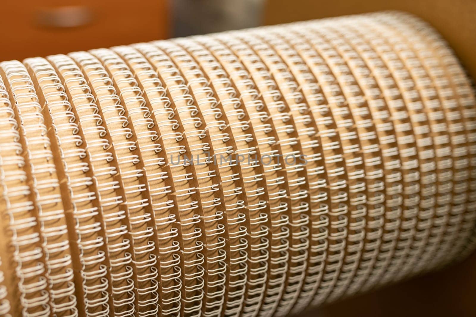 Rounded detail for professional machine tool with identical spirals for paper notebooks in workshop
