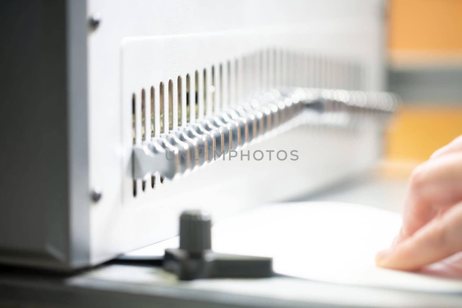 Crop unrecognizable female employee using manual bookbinder machine while creating new notebook in workshop