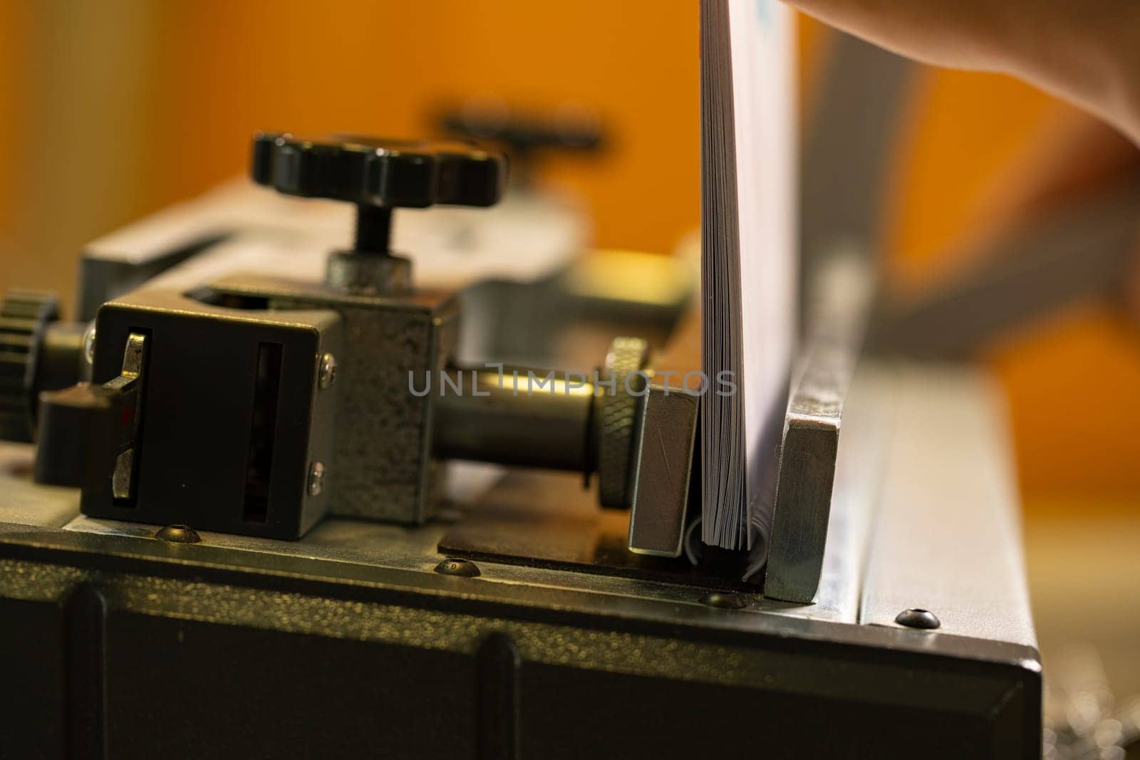 Paper spiral notepad between iron parts of professional typograohy machine tool in modern workplace