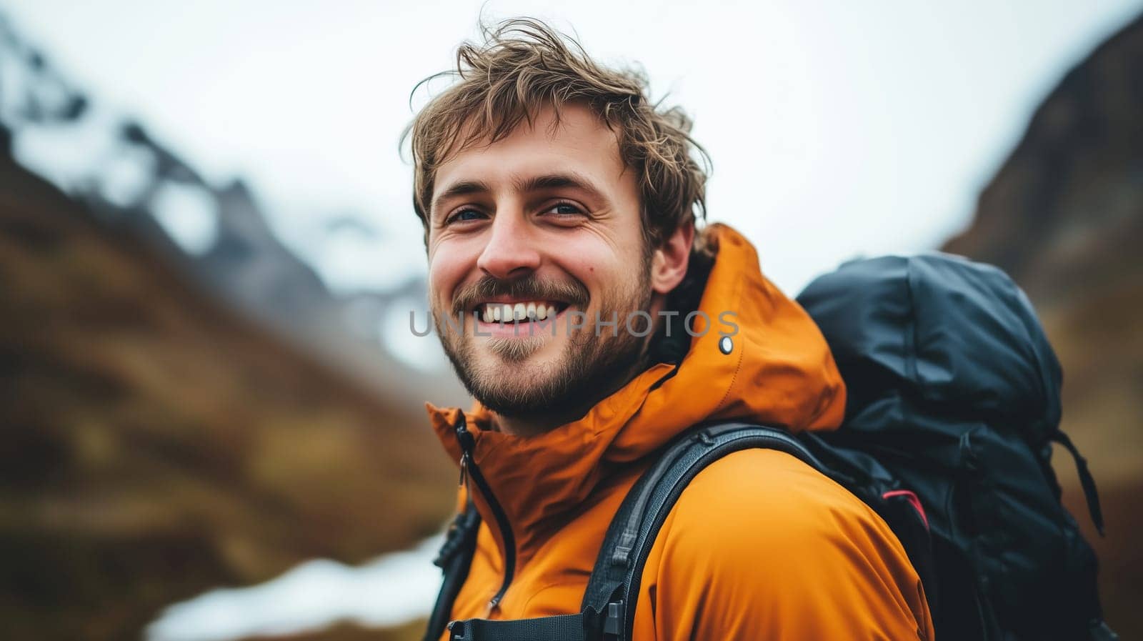 Travel, hiking, adventure, portrait of happy traveler hiker young man in jacket stands on top of snowy mountain looking at camera