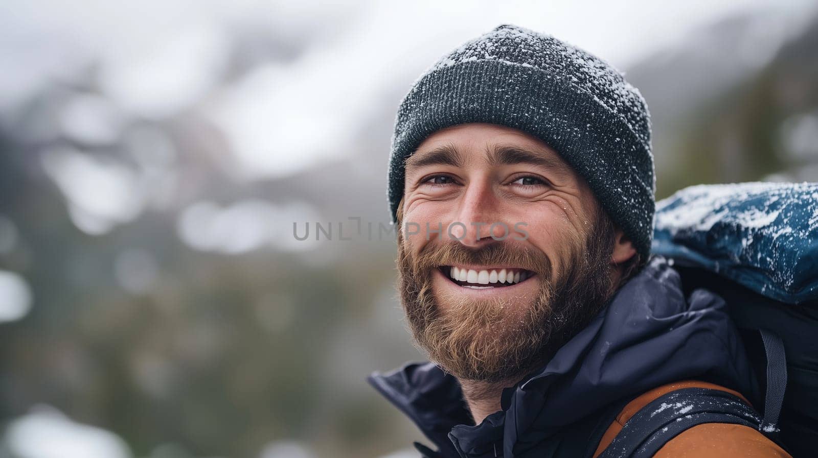 Travel, hiking, adventure, portrait of happy traveler hiker young man in jacket stands on top of snowy mountain looking at camera