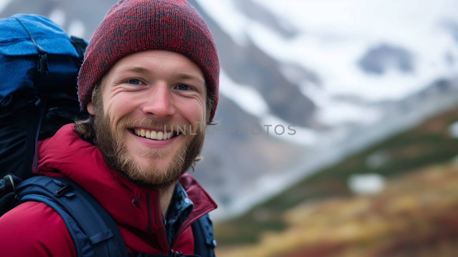 Travel, hiking, adventure, portrait of happy traveler hiker young man in jacket stands on top of snowy mountain looking at camera