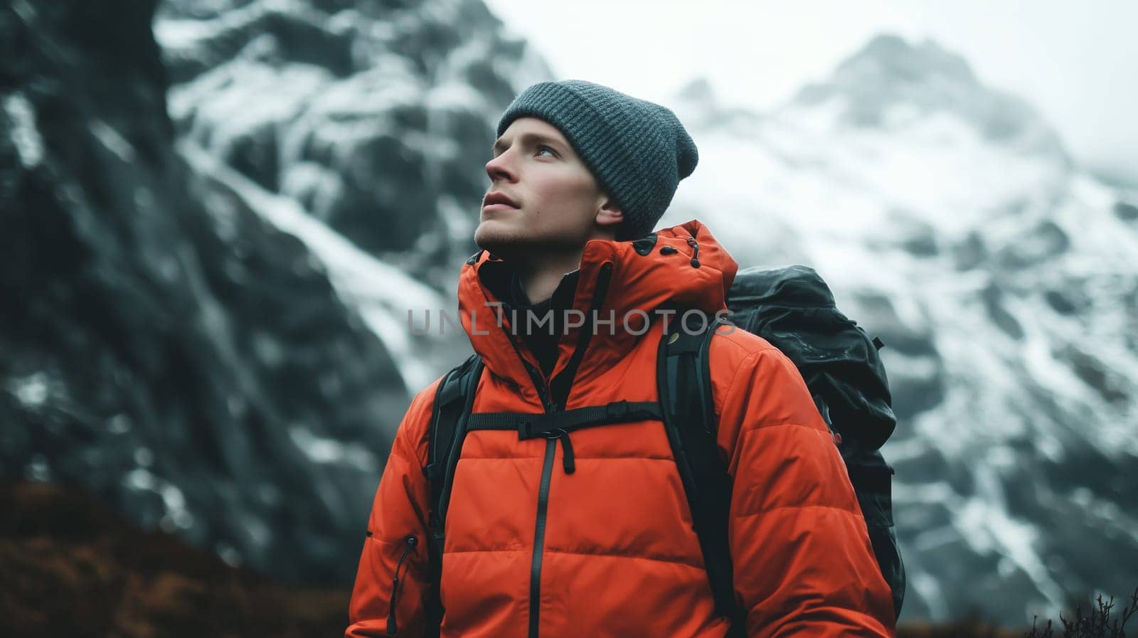 Travel, hiking, adventure, portrait of traveler hiker young man in jacket stands on top of mountain looking away
