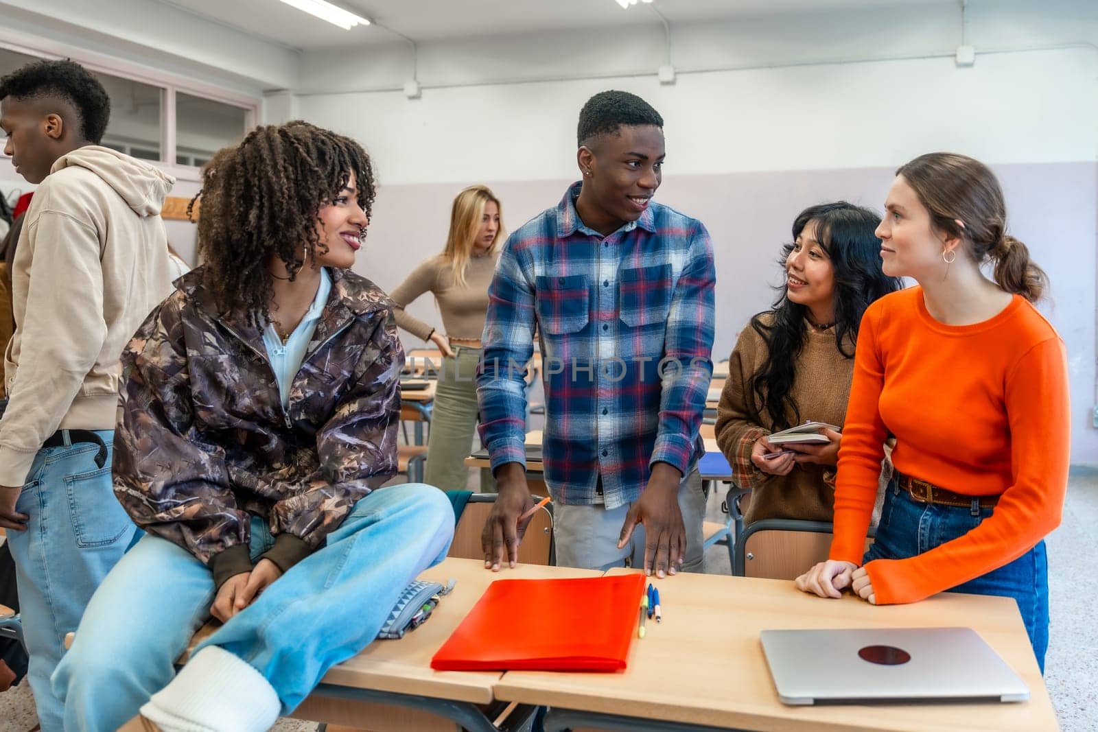 Diverse group of university students engaging in teamwork, discussing ideas and working together on a project in a classroom setting