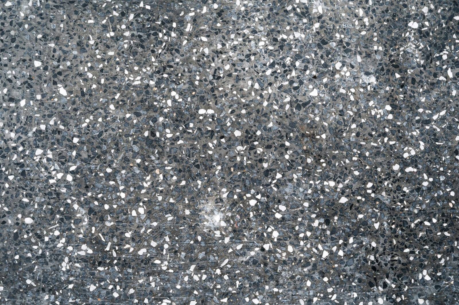 grainy abstract dark texture with crumbs of white stones. Paving pattern