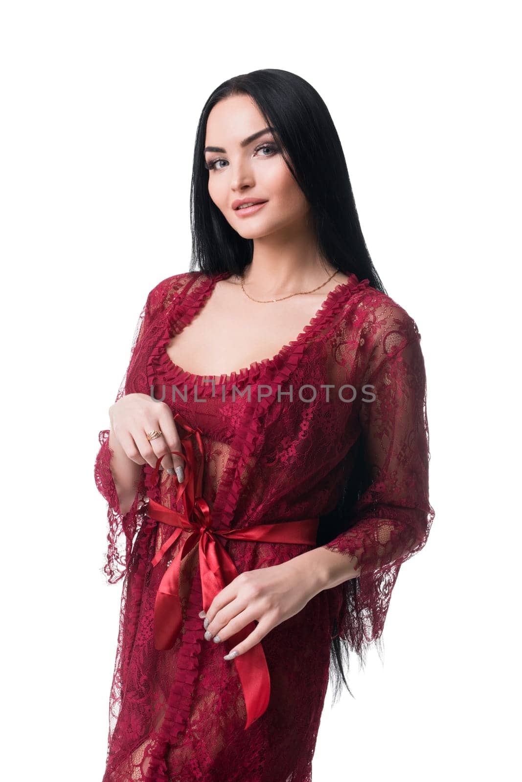Sexy graceful brunette female wearing red lace underwear isolated on white background in studio and looking playful at camera