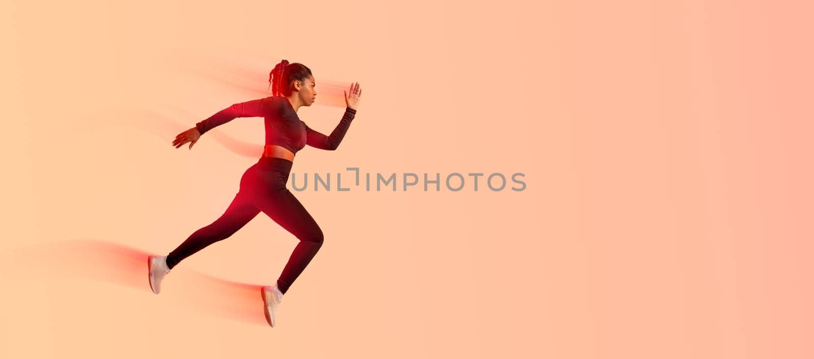 African american professional woman athlete, runner training isolated on neon colored studio background, panorama, copy space, side view. Action, motion, speed, healthy lifestyle