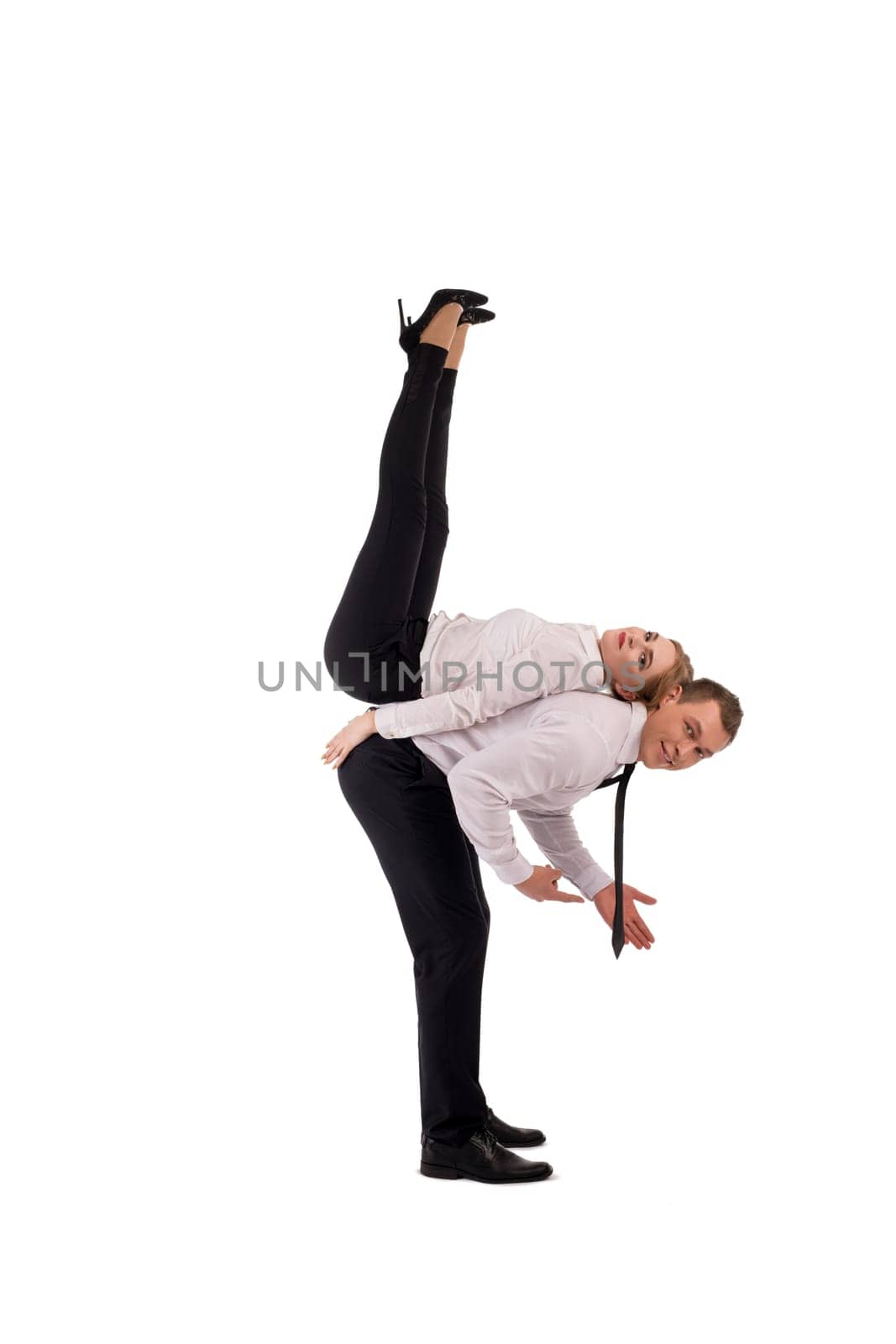 Full body side view of confident businessman carrying female partner on shoulder as concept of cooperation with notebook and cell phone